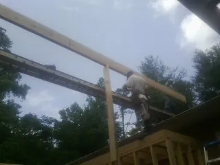 Carpenter setting a ridge beam over a new addition frame — Ice Dam Removal by Roofing Brothers in Cannon Beach