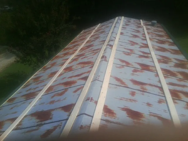 Rusted metal roof panels with new wood purlins before replacement — Storm Damage Roof Repair in Cannon Beach by Roofing Brothers