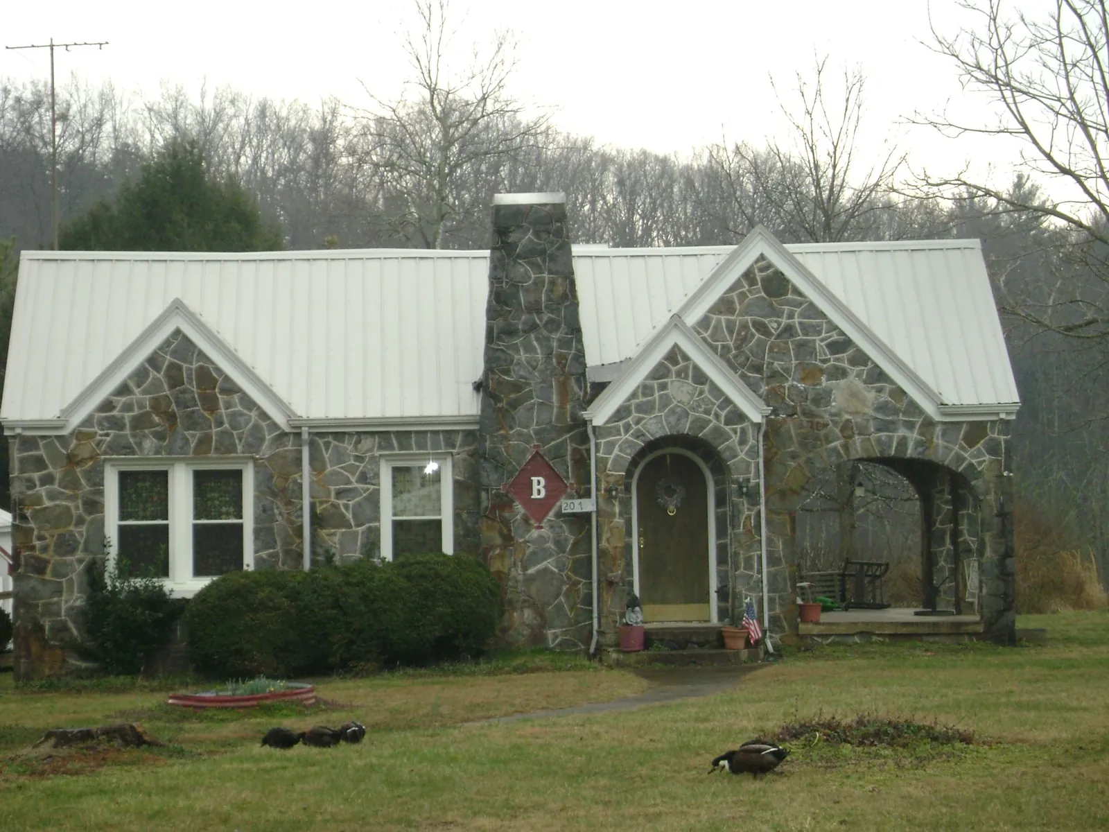 White metal roof on a stone cottage with steep gables in Cannon Beach
