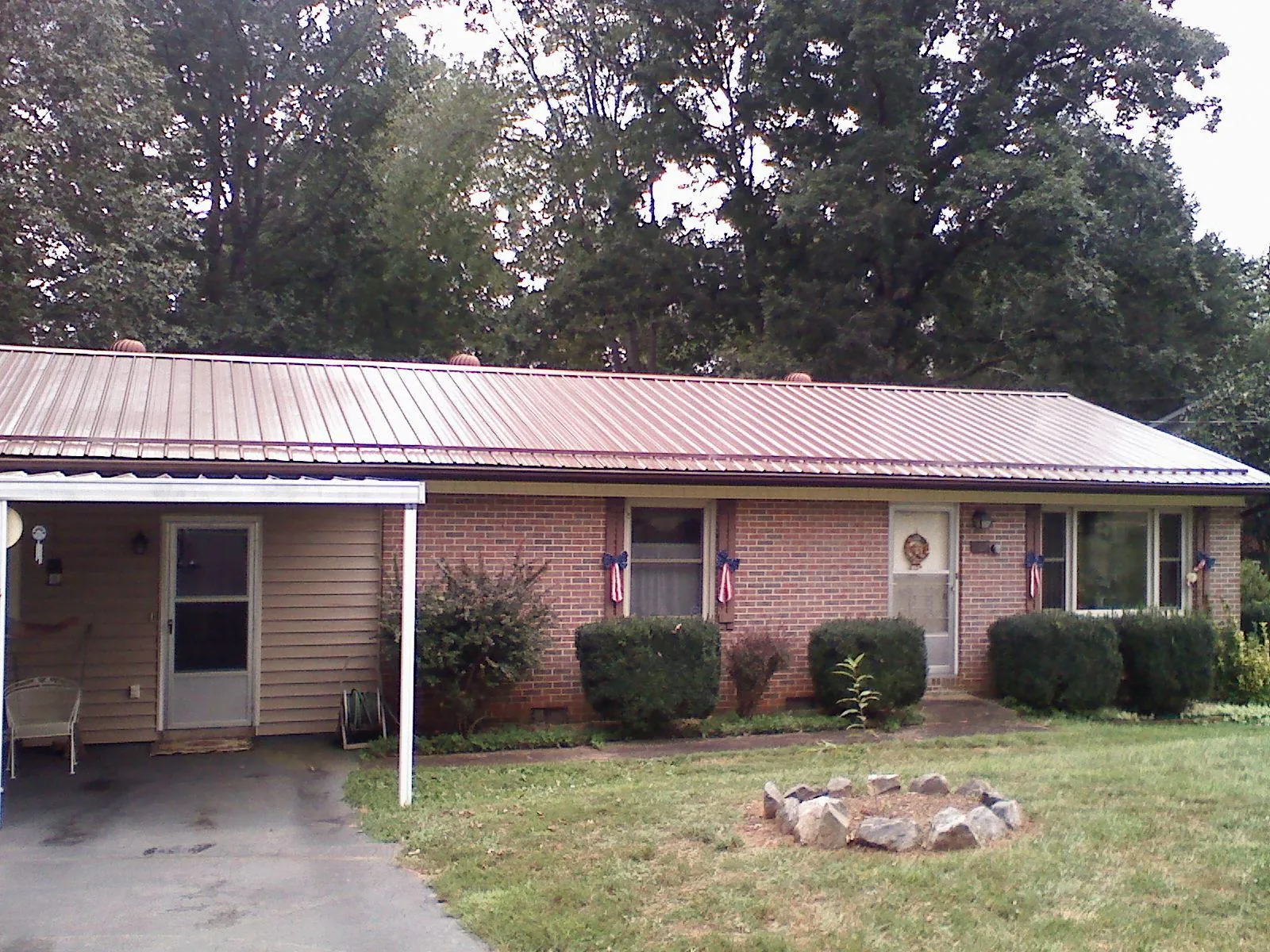 Bronze metal roof and carport on a brick ranch home — Roof Repair work by our crew in Cannon Beach